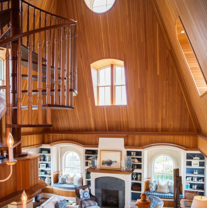 A living room area with high ceilings and a spiral staircase.