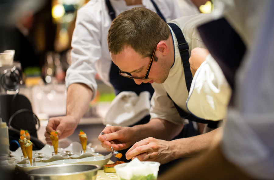 A chef making adjustments to a dish.