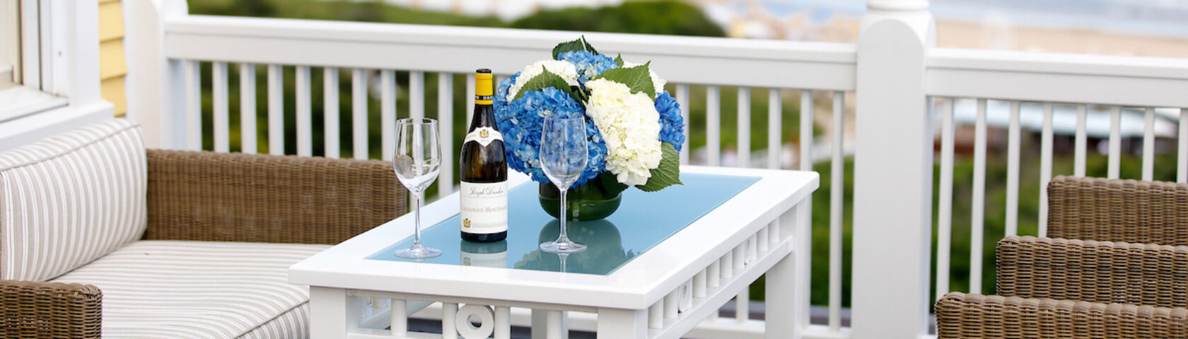An outdoor lounge area set with flowers and champagne.
