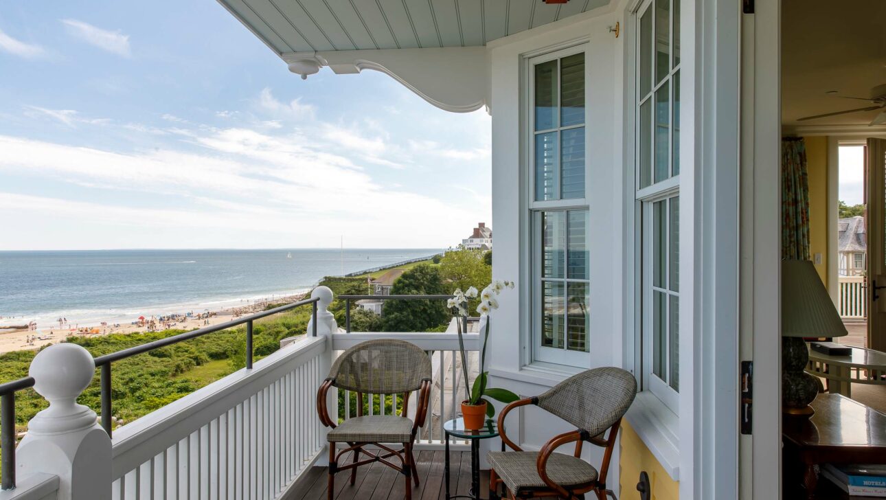 A veranda with two chairs overlooking an ocean view.