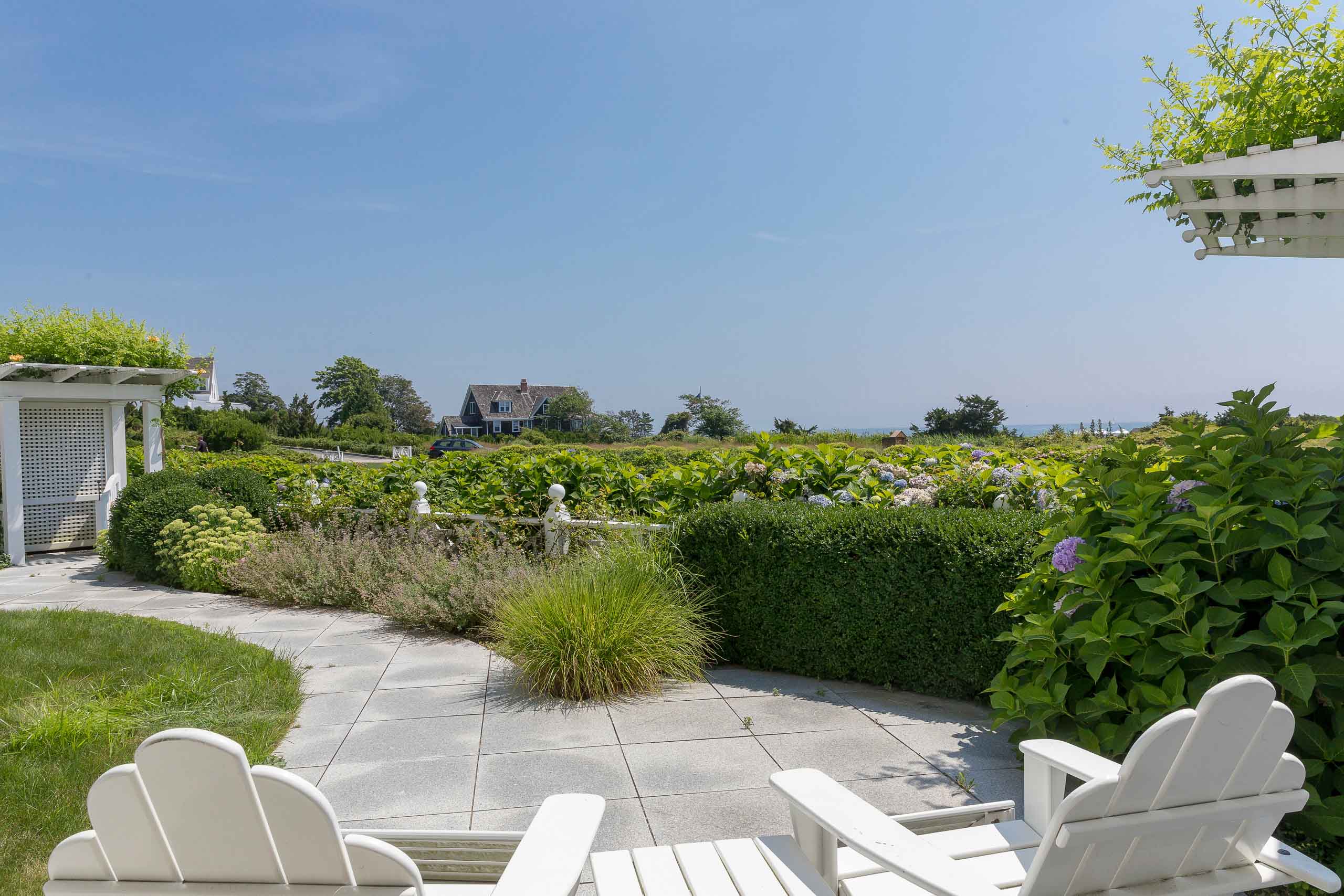 Two lawn chairs facing a garden.