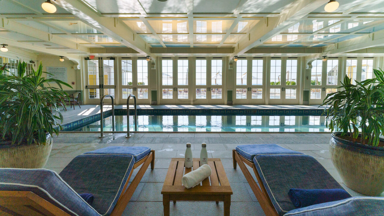 An indoor pool with lounge chairs.