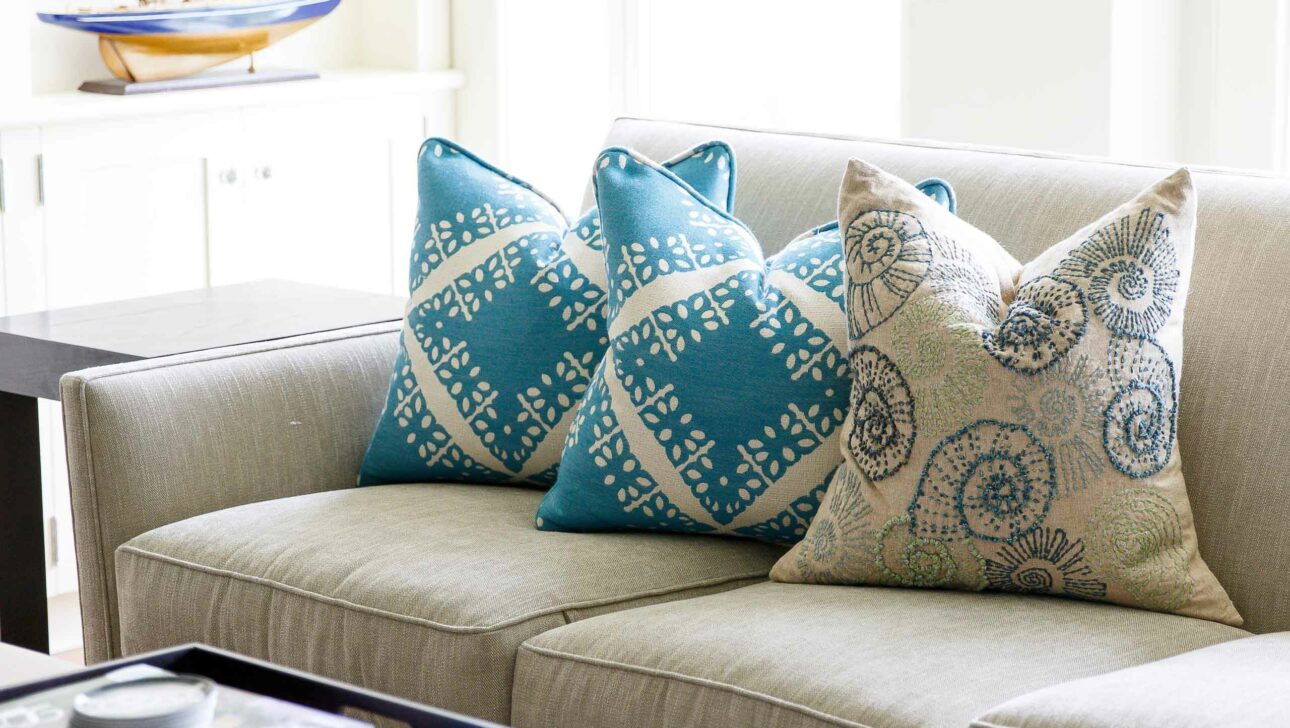 A couch with three throw pillows.