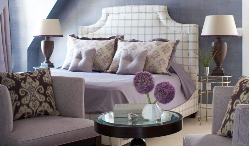 A Lighthouse Suite bedroom with purple bedding.