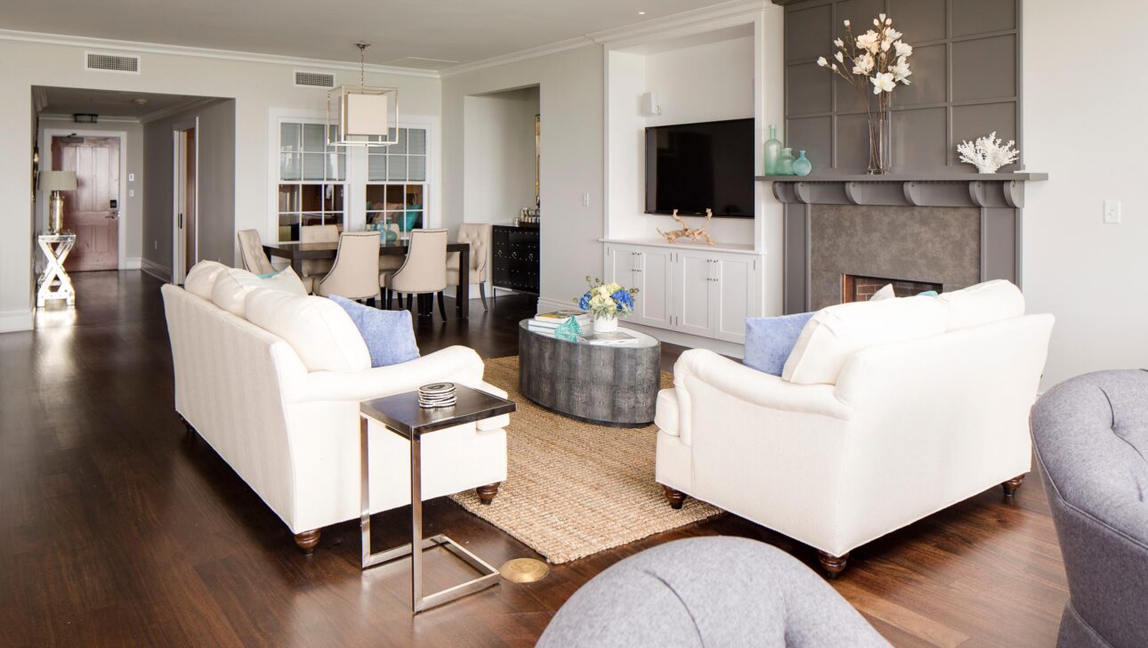 Sea Glass Suite living room with two white couches and a fireplace.