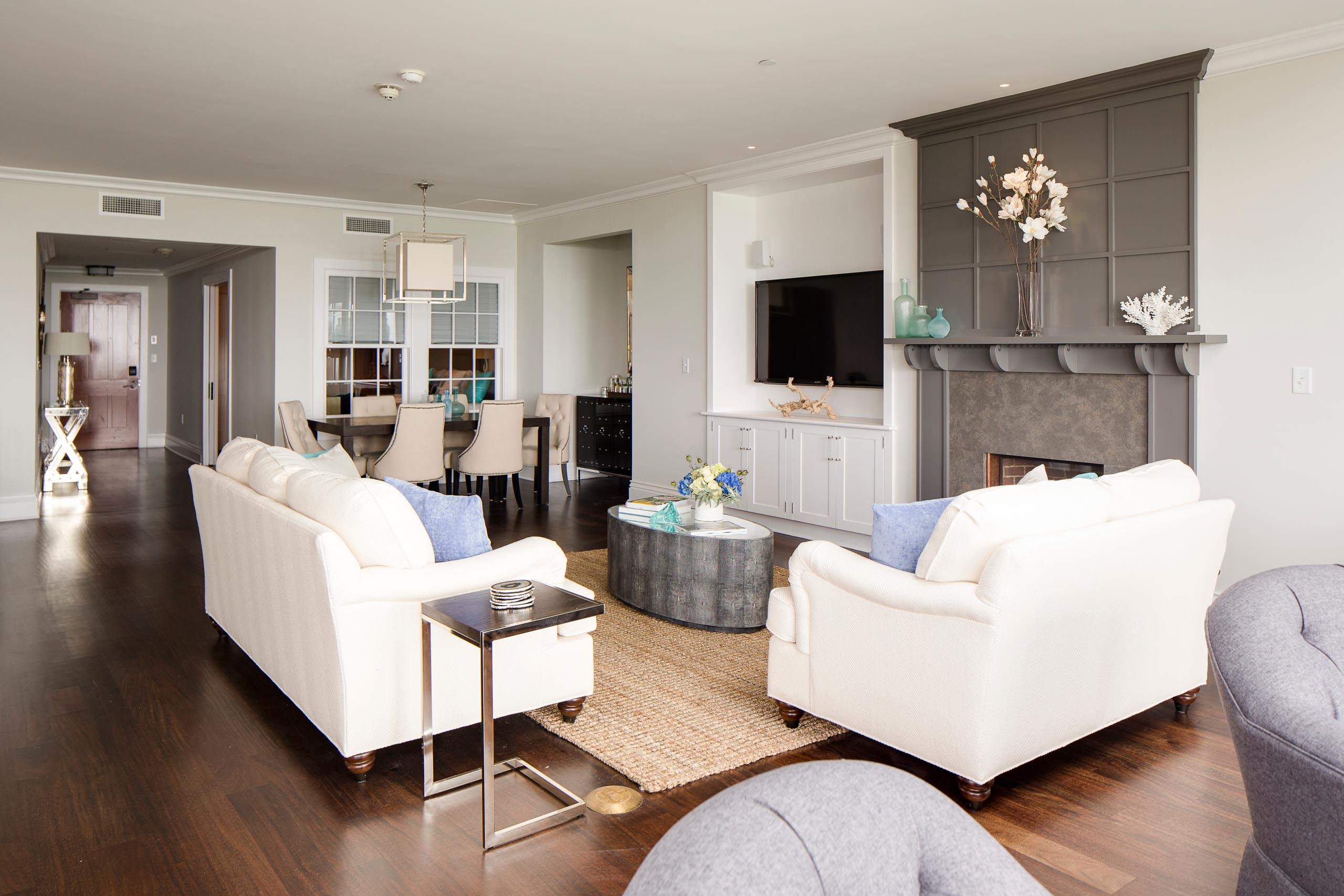 Sea Glass Suite living room with two white couches and a fireplace.