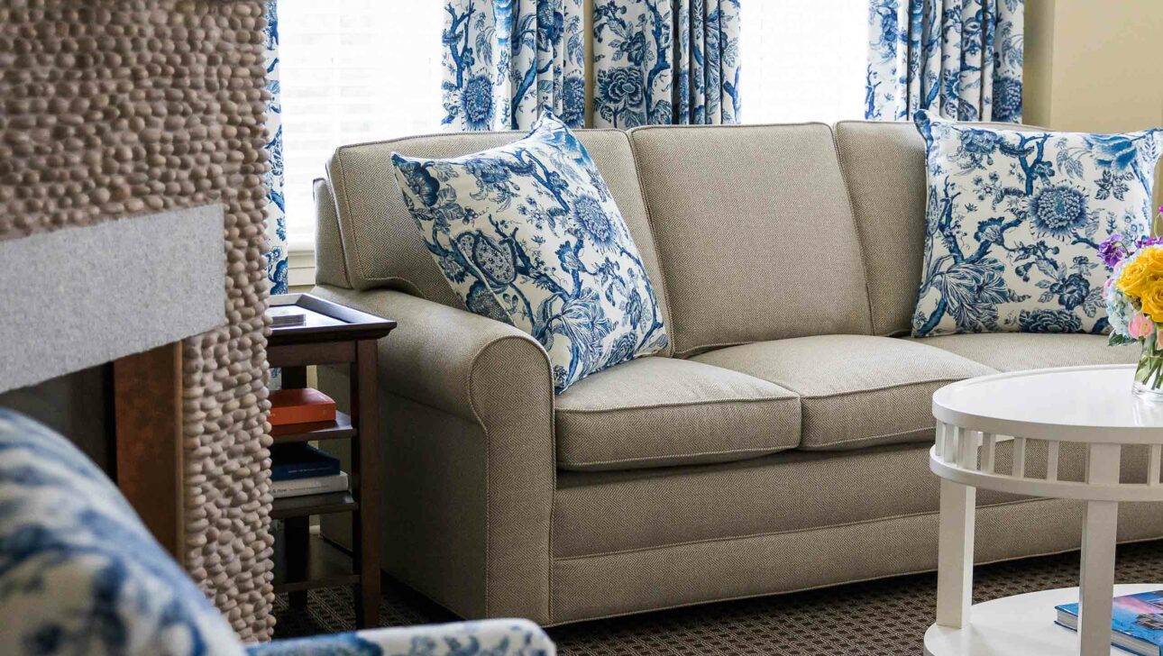 A couch with blue and white pillows.