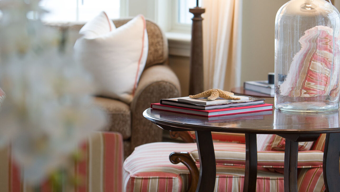 Narragansett Suite side table in the living room with a lamp and books.