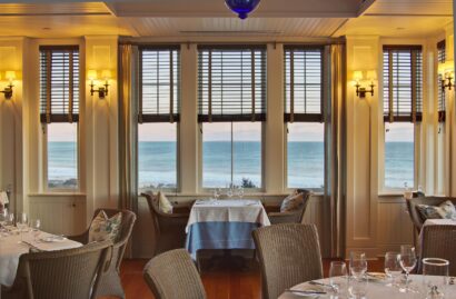 Coast restaurant dining area with windows showing an ocean view.