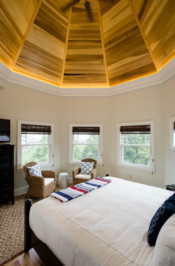 A bedroom in Echo Lodge with two chairs and several windows.