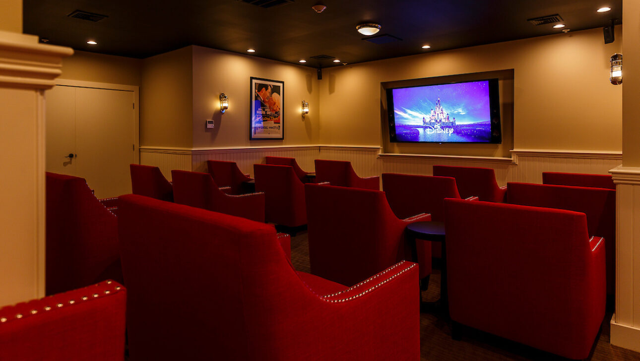 A screening room with rows of red chairs.