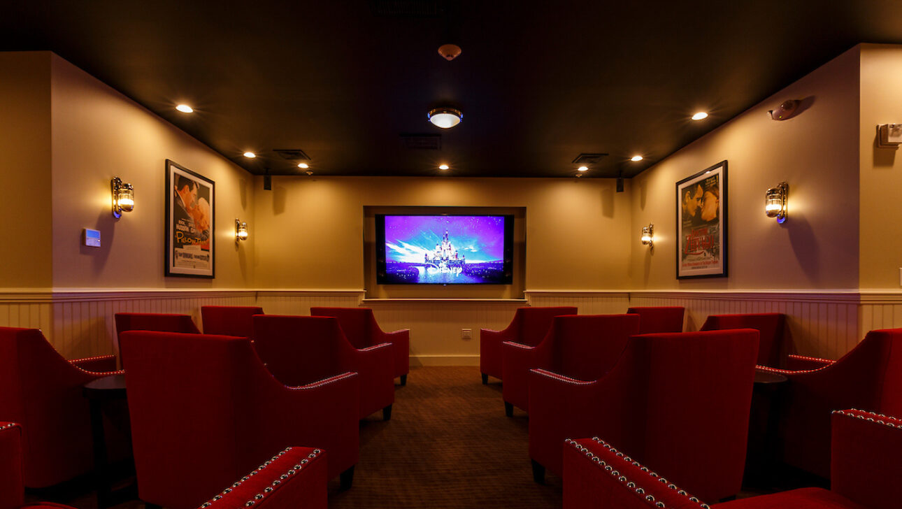 A screening room with red chairs.