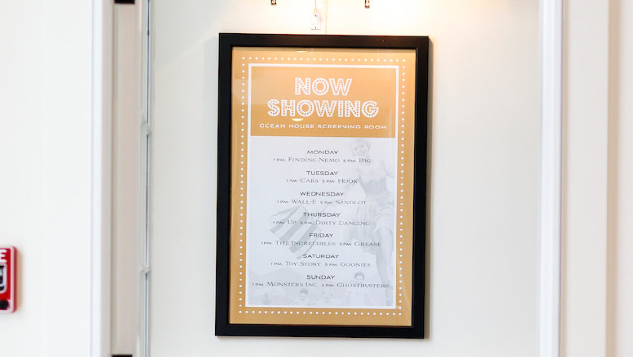 The entrance to the screening room with a poster that reads, "Now Showing".