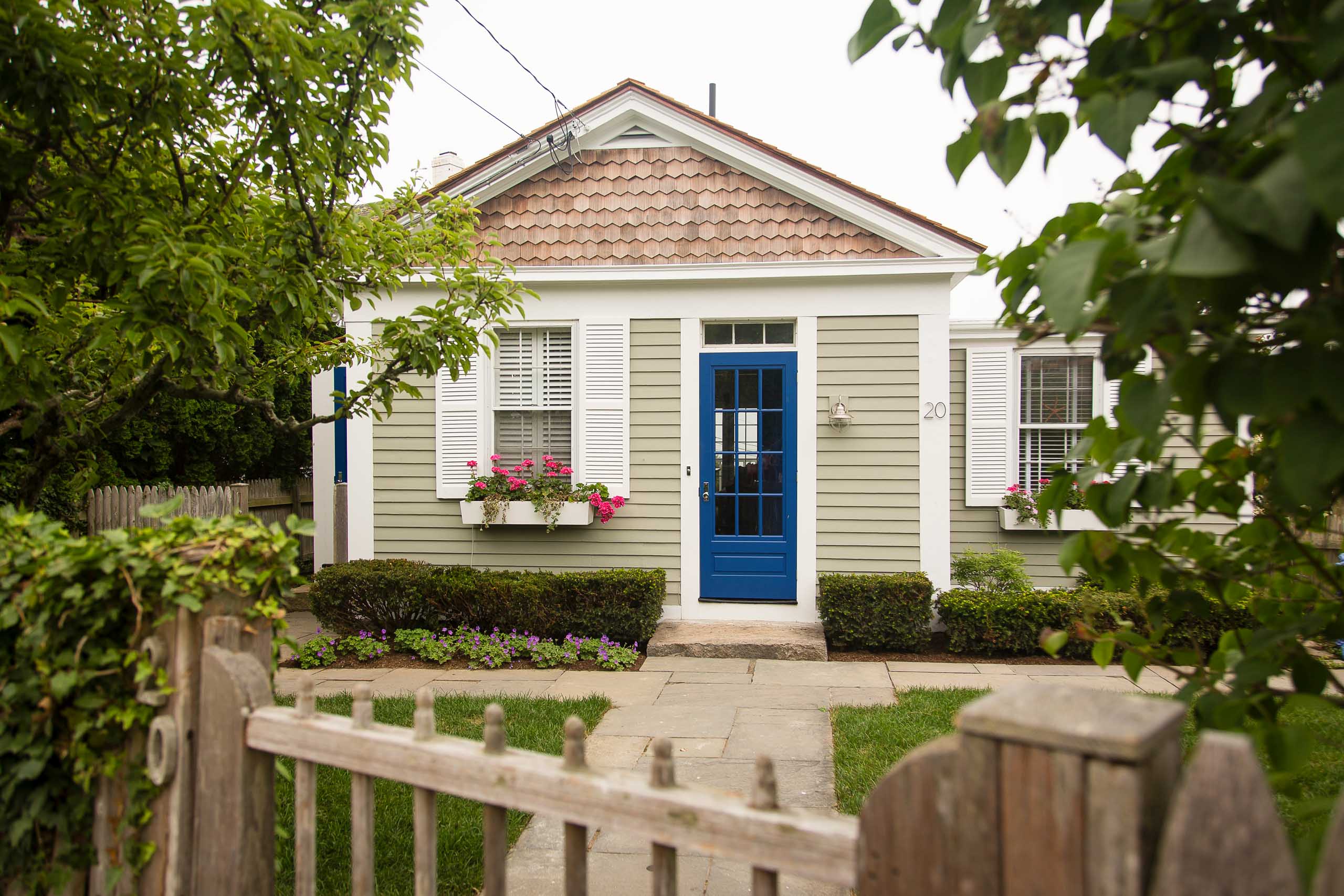 The outside of a cottage with a blue door.