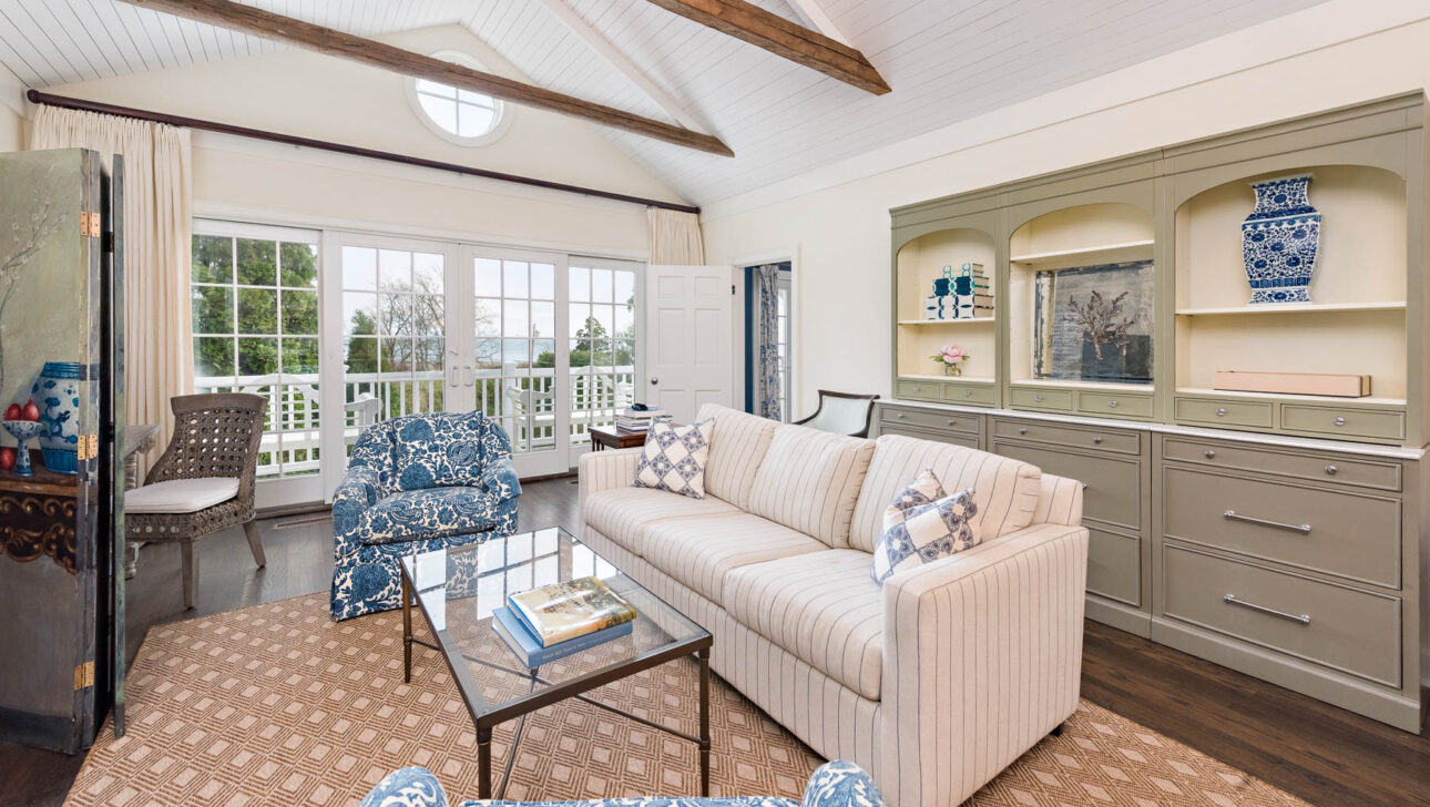The School House cottage living room with a white couch and glass coffee table.