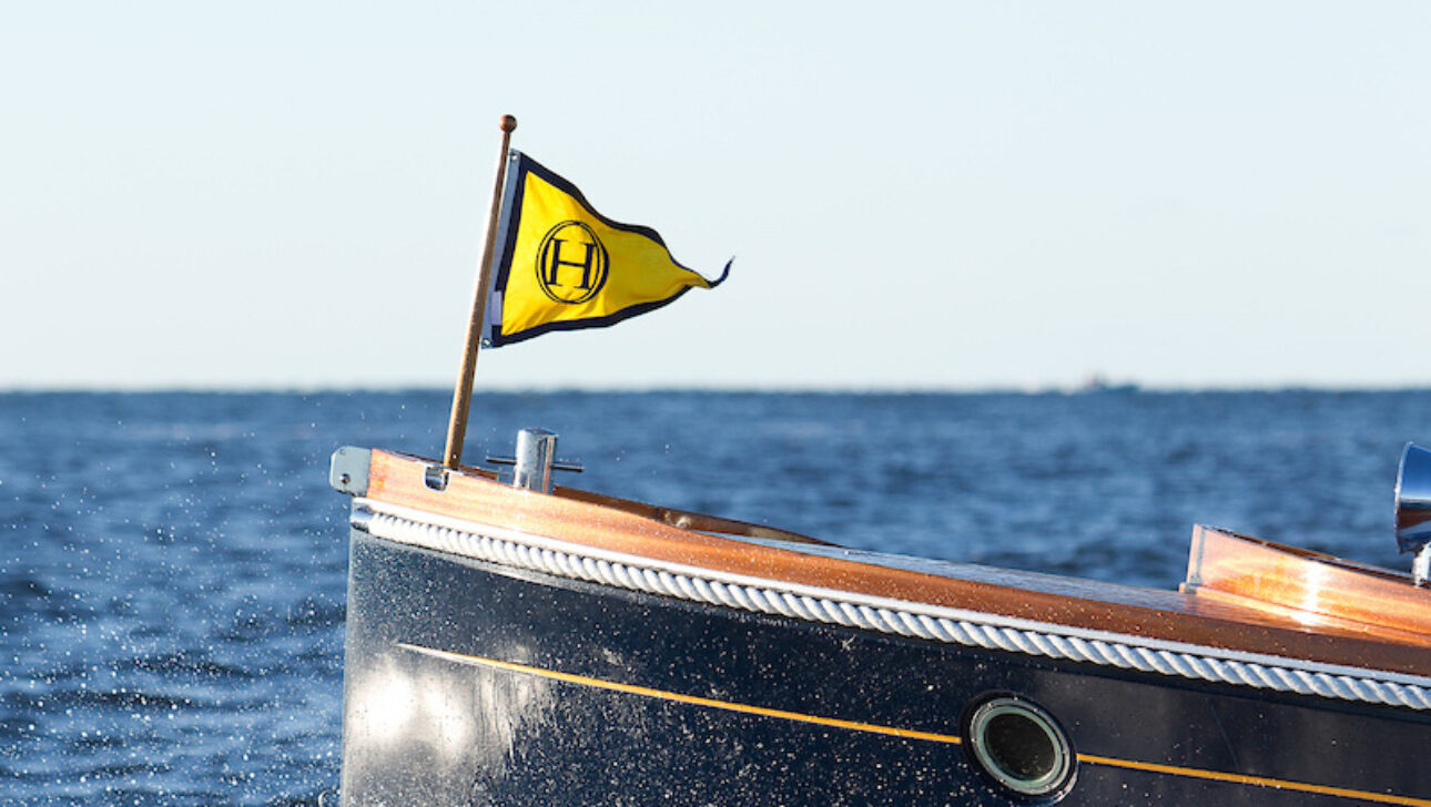 A close up of a yacht with a yellow flag.