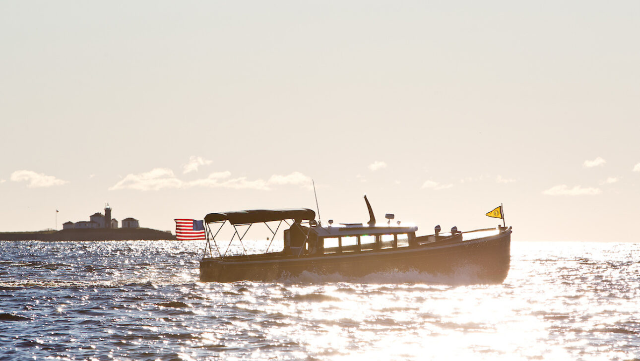 A yacht on the water as the sun sets.